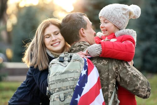 Veteran hugging family