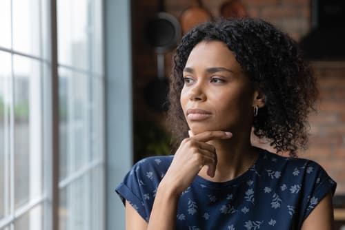 woman looking out window in thought