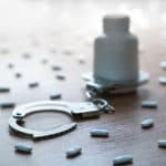Pill bottle with handcuffs