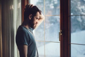 Man who is depressed and sad looking out the window
