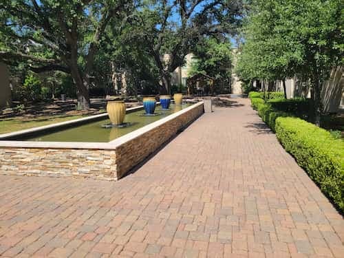 paved walkway next to decorative fountains